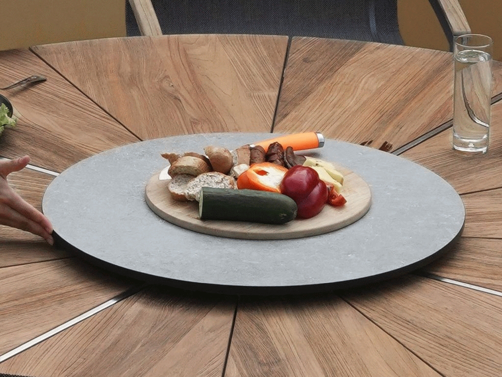 In die strahlenförmig angeordneten Teakholz-Planken der ORXY ERDE Tischplatte sind feine Edelstahlstreben eingelassen – sie verleihen dem Tisch eine zeitlos moderne Ausstrahlung.