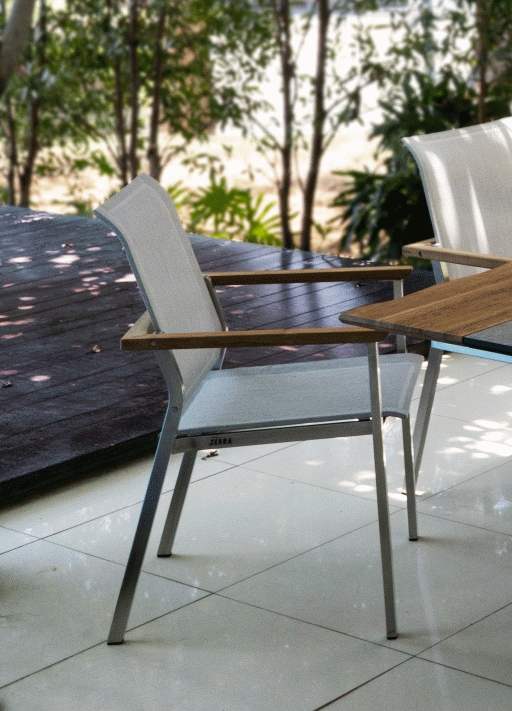 Der INFINITY Sessel kombiniert Teakholz-Armlehnen und Batyline®-Eden-Textil zu zeitloser Eleganz und langlebiger Funktionalität